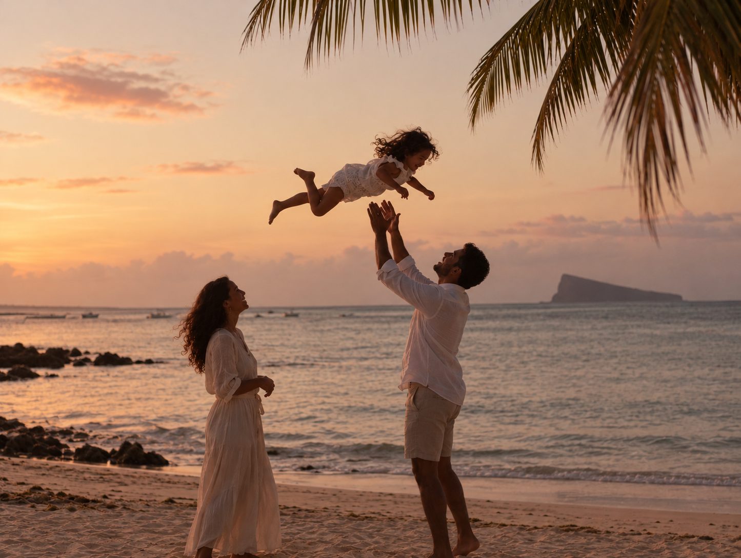 A family playing on the beach at sunset in Mauritius